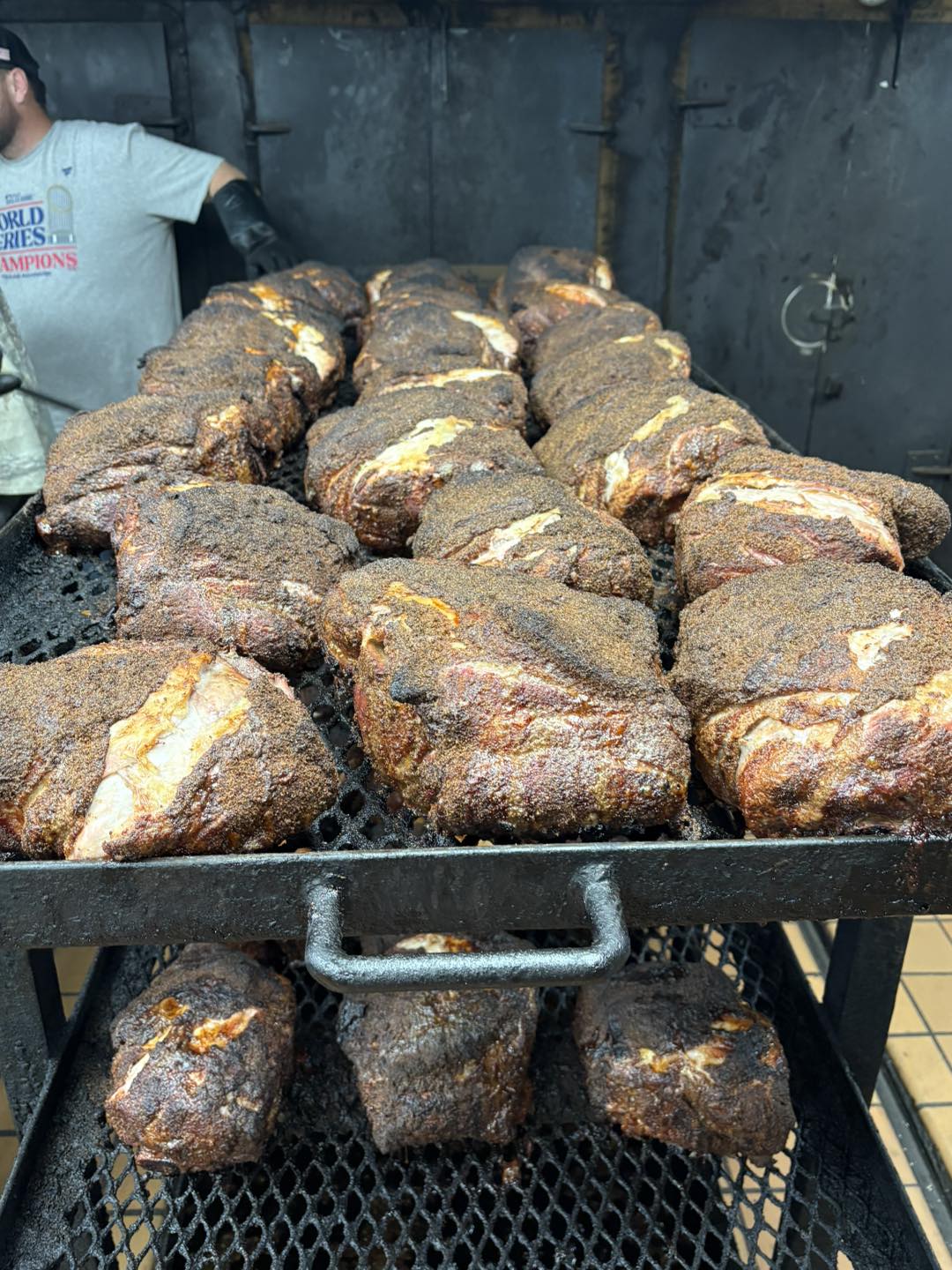 Seasoned meat pieces on smoker rack