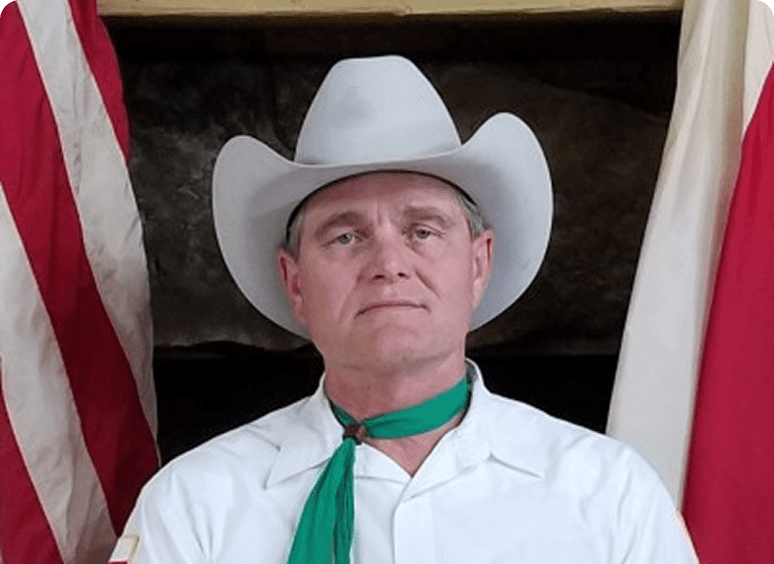 Man in cowboy hat with green scarf
