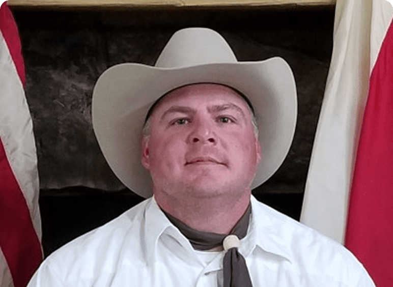 Man wearing cowboy hat and scarf