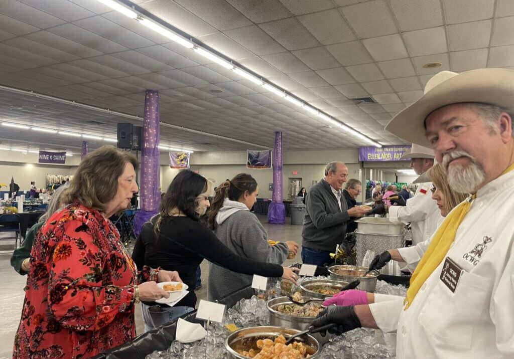 People serving food at a buffet event.